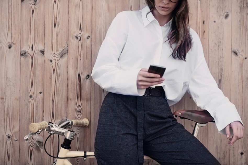 Une femme sur son téléphone au style masculin-féminin