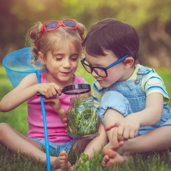 Des enfants suivent des cours en plein air. 