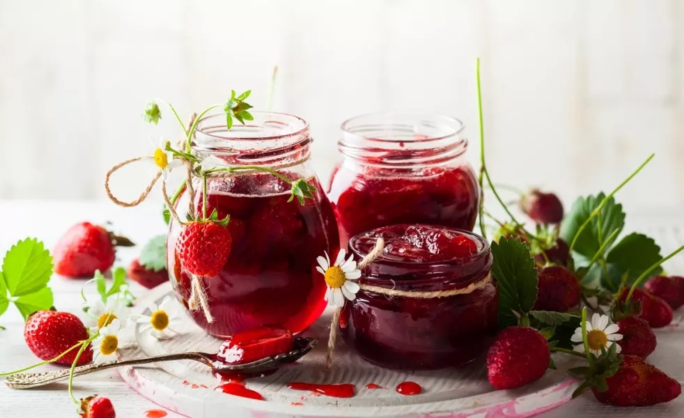 Des pots de confiture à la fraise sur une table