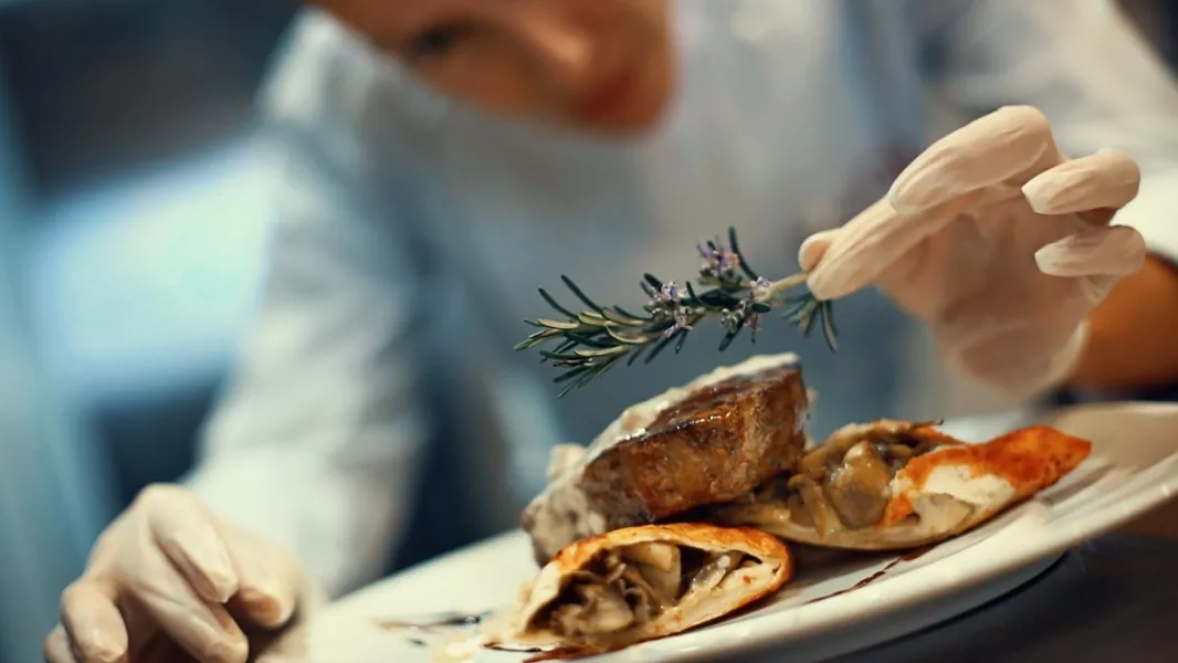 Une femme chef dresse une assiette