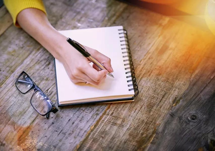 Une femme écrit sur un carnet.