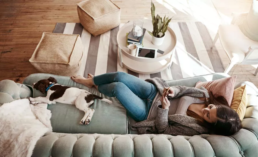 Une femme s’accorde une pause avec un livre et une tasse de thé.