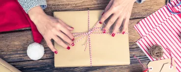 Une femme emballe un livre de cuisine pour l’offrir à Noël
