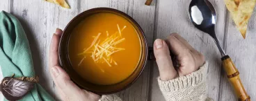 Une femme tient un bol de soupe 