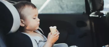 Un enfant qui mange une glace dans une voiture