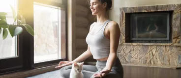 Séance de méditation à la maison pour une jeune femme et son chat