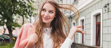 Une femme classe et souriante dans la rue au style bohème