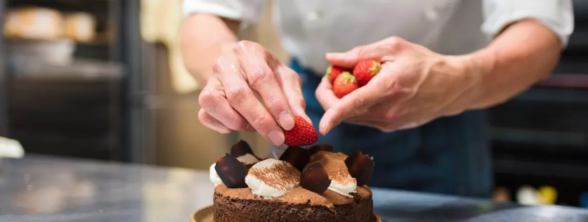 La pâtisserie française, un joli péché mignon Un chef patissier élabore un gâteau au chocolat et aux fraises