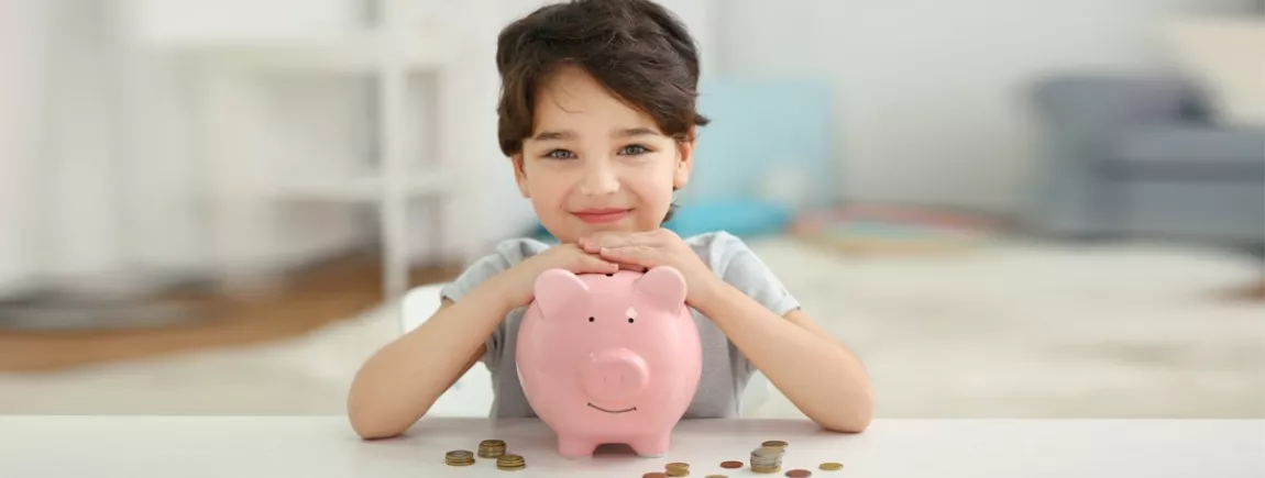 Un enfant range son argent de poche dans sa tirelire.