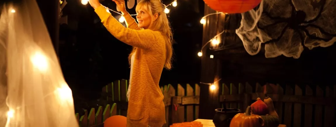 Une femme installe des décorations pour fêter Halloween