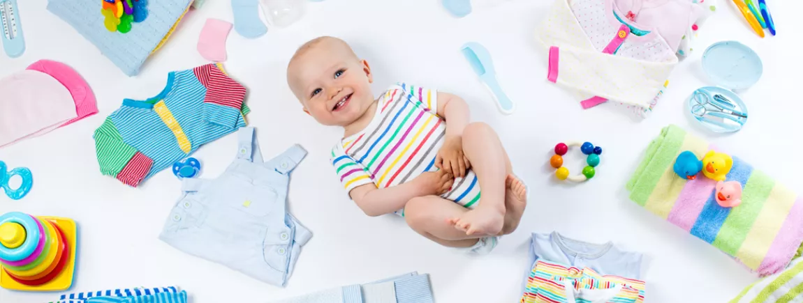Vêtements bébé d’occasion, le compromis mode à prix tout doux ! Un bébé entouré de sa garde robe
