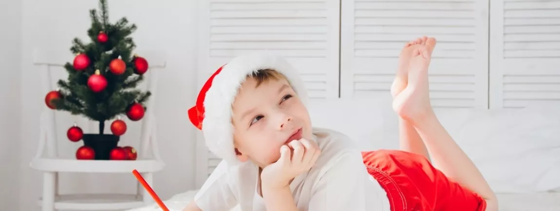 Imprimez un modèle de lettre au Père Noël avec Lulu® Un petit garçon allongé sur un lit écrit au Père Noël