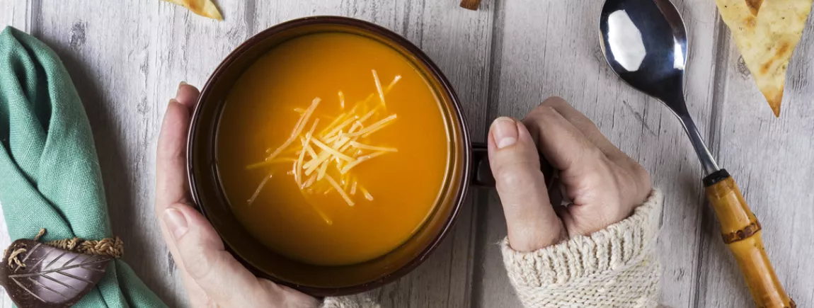 Une femme tient un bol de soupe 