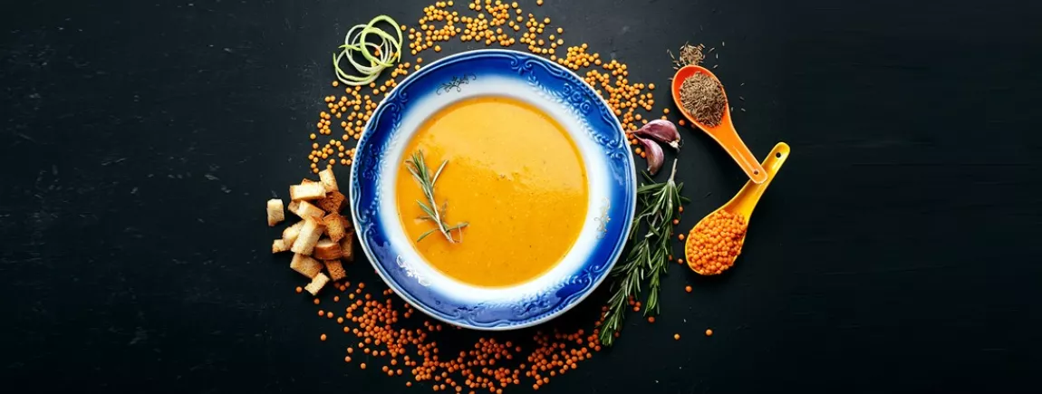 Soupe patate douce, curry, lentilles corail Une assiette de soupe disposée sur une table