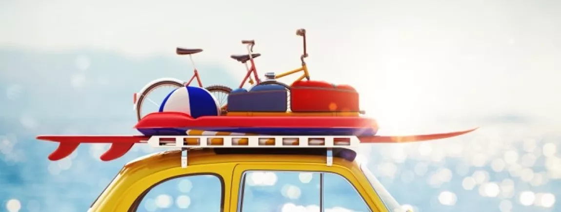 Vacances : bien charger sa voiture en 10 astuces ! Le toit d’une voiture jaune chargé de vélos et bagages pour les vacances