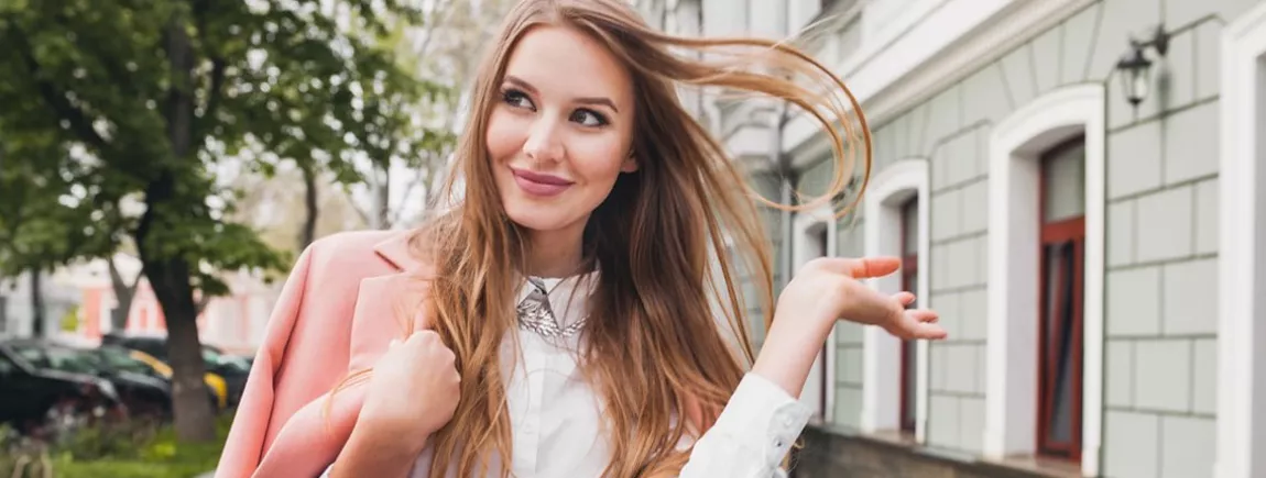 Une femme classe et souriante dans la rue au style bohème