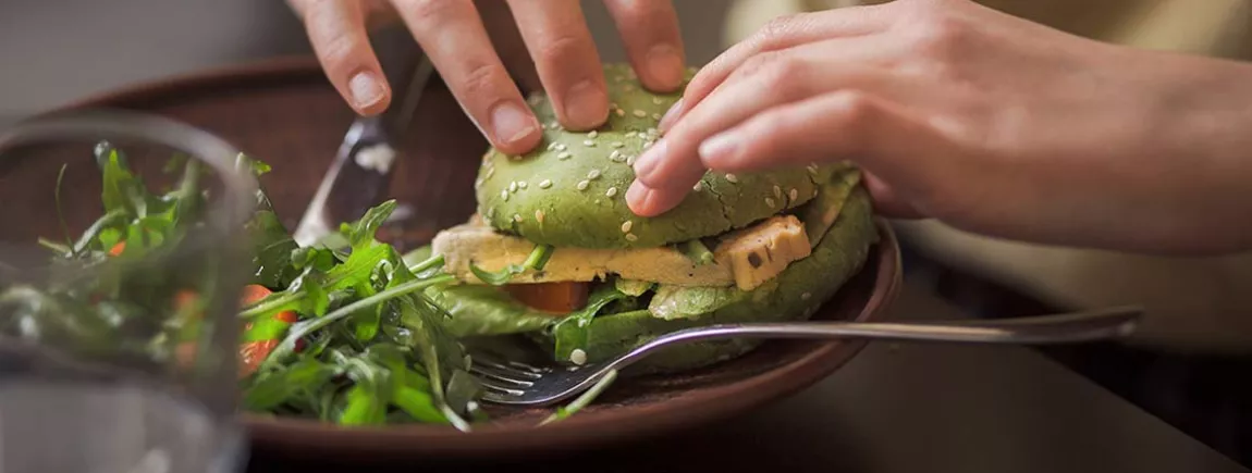 Toutes folles des nouvelles tendances food ! Une personne mangeant un hamburger végatal