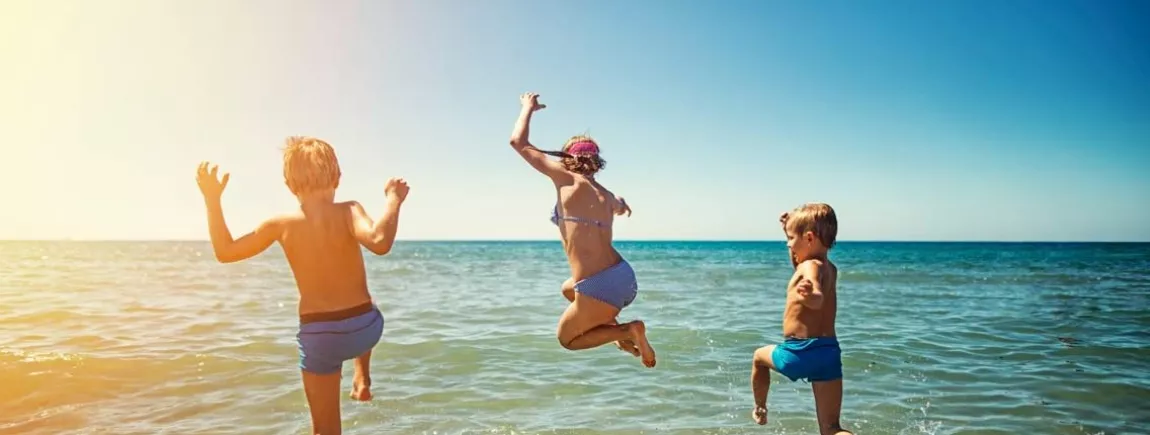 De bonnes vacances… ça se prépare ! Une famille court sur une plage pour se baigner