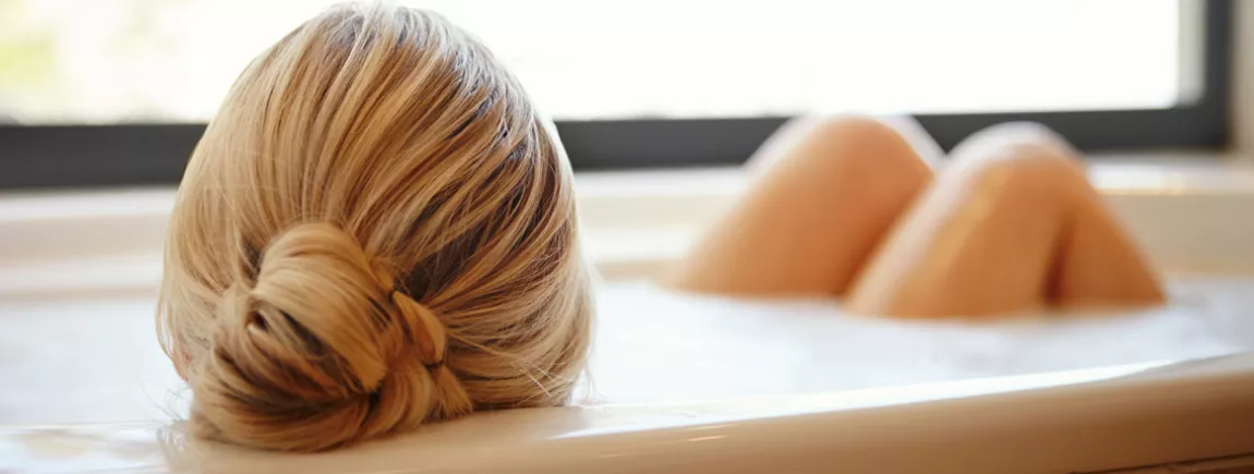 Les plaisirs d’un bon bain chaud Une femme prend son bain.