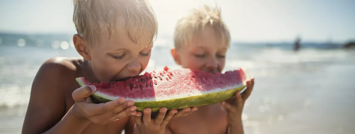 4 idées Pépito® pour un goûter encore plus fun ! enfants à la plage mangeant une pastèque