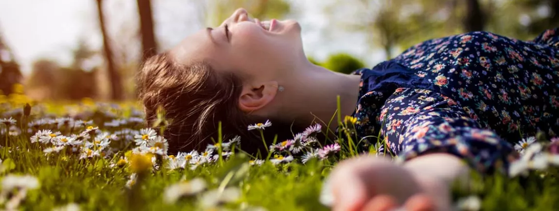 Les 10 bonnes façons de profiter des jours fériés Une femme est allongée dans l’herbe dans un parc.
