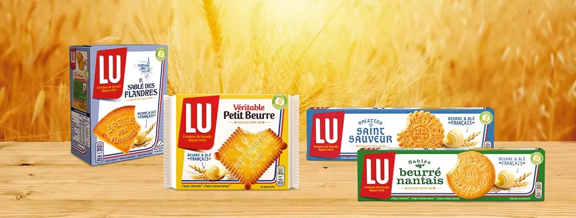 Découvrez les secrets des recettes régionales LU® Des packs de biscuits LU sur une table avec en fond un champ de blé