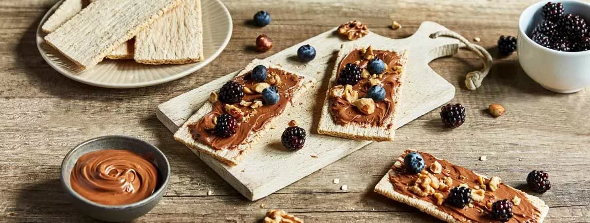 Cracotte® gourmande aux fruits des bois Des Cracotte recouvertes de Patamilka et de fruits sont sur une table