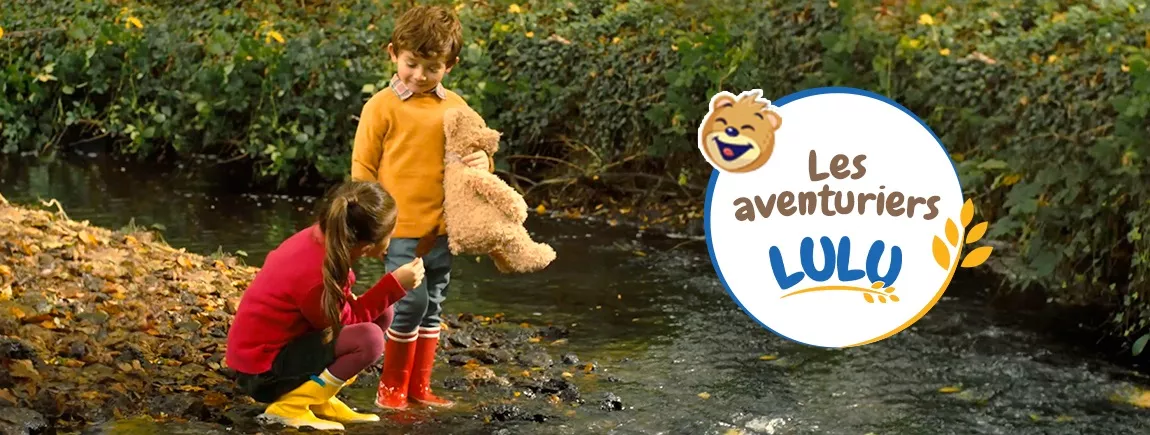 Des enfants au bord d’une rivière.